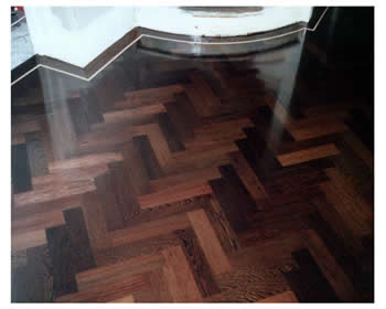 New parquet wood flooring, Guildford. Wenge parquet wooden floor in a herringbone pattern with a maple border..